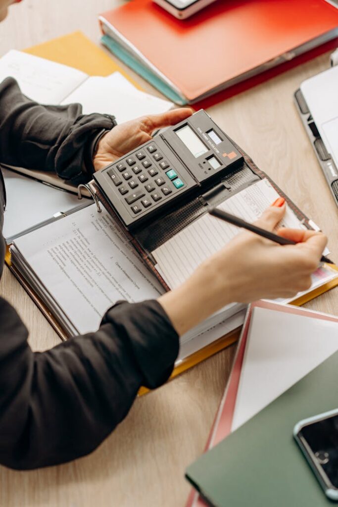 Hands using a calculator during paperwork in an office setting. Ideal for business concept visuals.